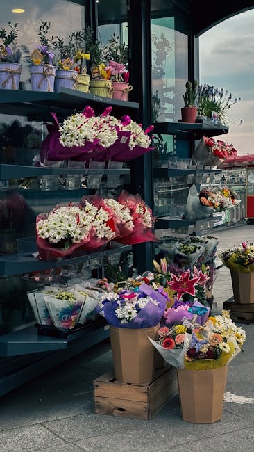 A display of fresh floral arrangements and bouquet arrangements at a flower shop near Harpenden station, featuring a variety of colorful flowers such as white chrysanthemums, pink lilies, purple irise